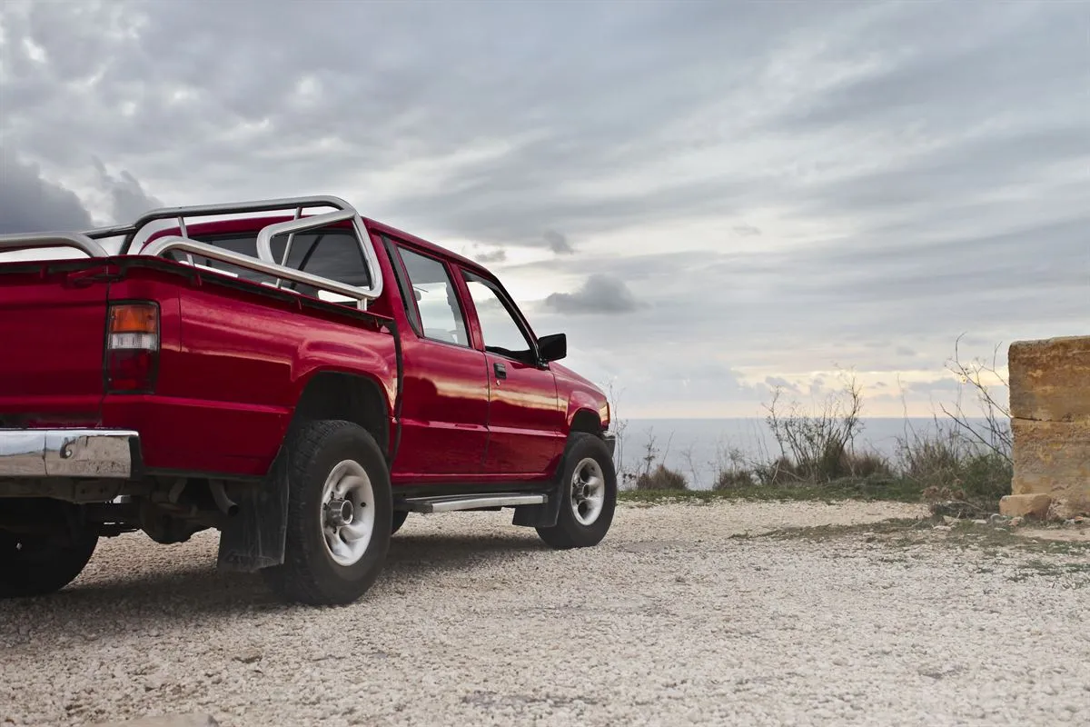 Red pickup truck parked outside a workshop